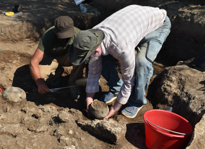 Fotografia che ritrae due archeologi in una fase dello scavo delle urne funerarie